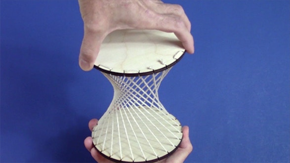 Hands holding the top and bottom of a hyperboloid model
