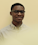 Headshot of Daniel Alabi - Black man in stripe collared shirt with glasses on