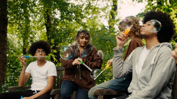 People blowing bubbles outside.