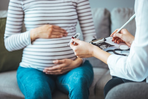 A pregnant woman during a routine check up with her doctor.