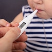 Person's Hand Checking Fever Of Sick Girl
